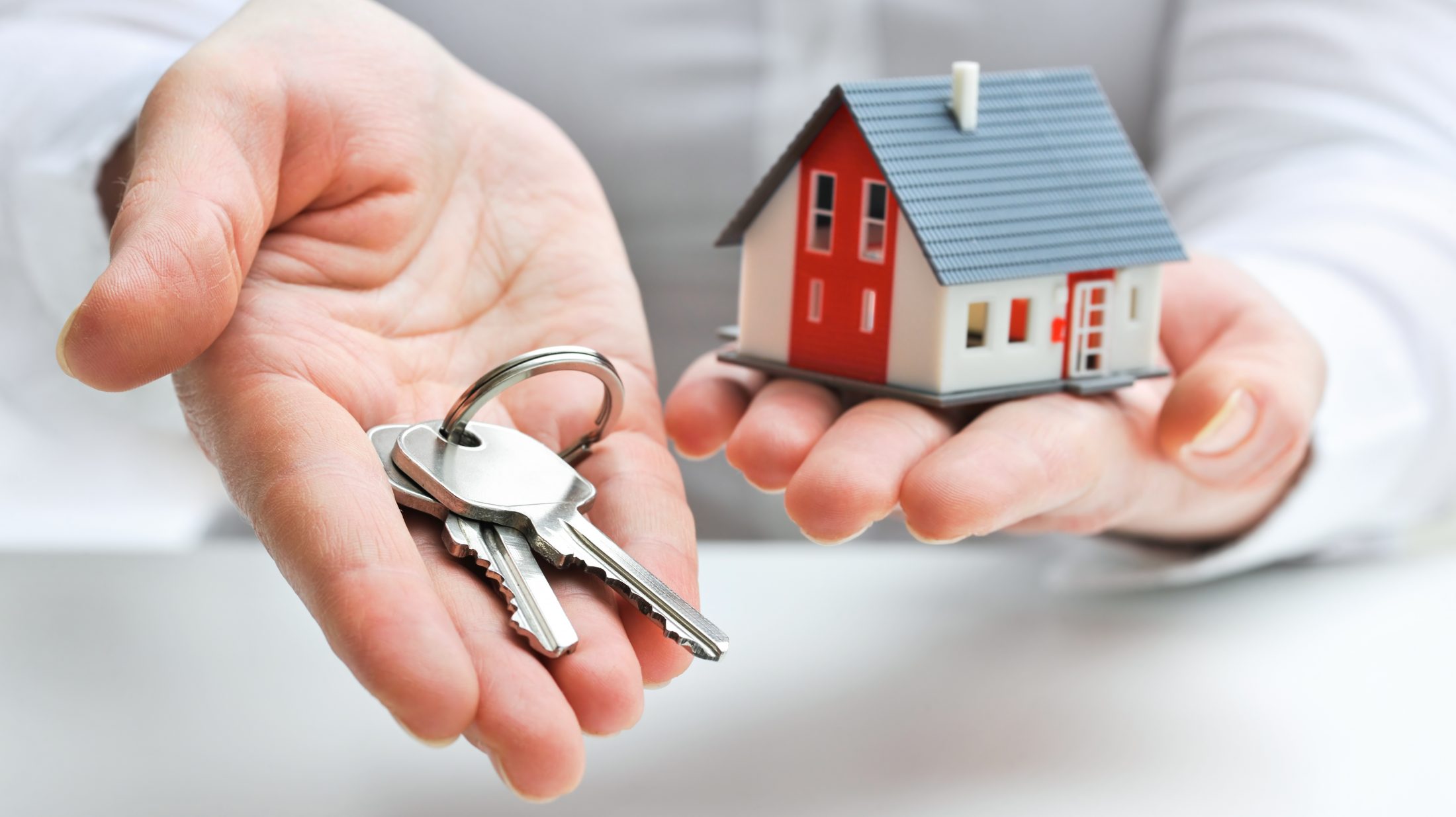 Real estate agent with house model and keys